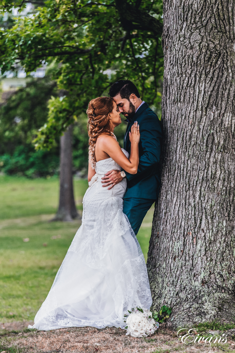 Wedding couple poses directly in front of the camera against the background  of a stone wall