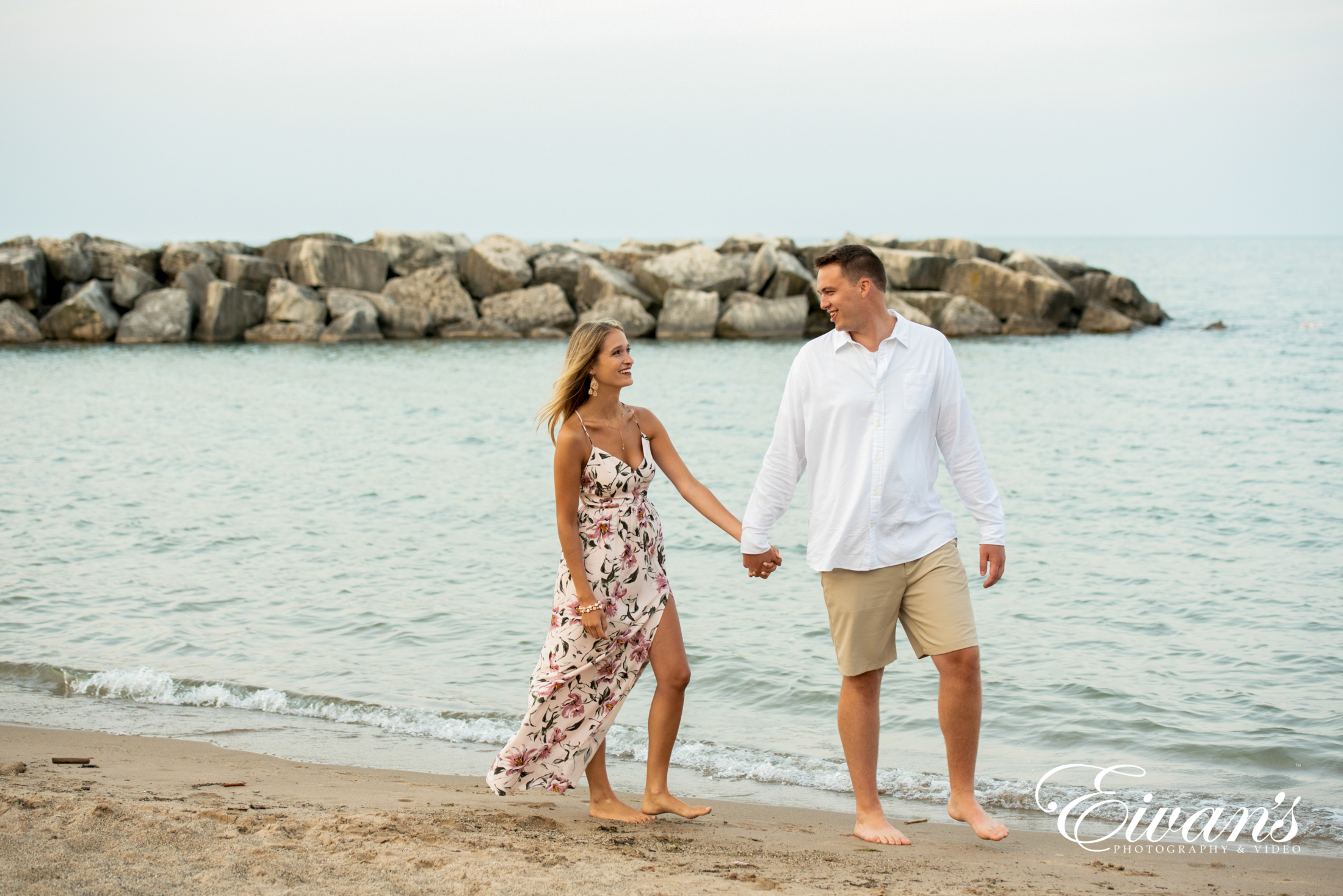 image of engaged couple walking on the beach